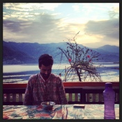 Humble Yogishi drinks tea at his dining table overlooking Phewa Lake.